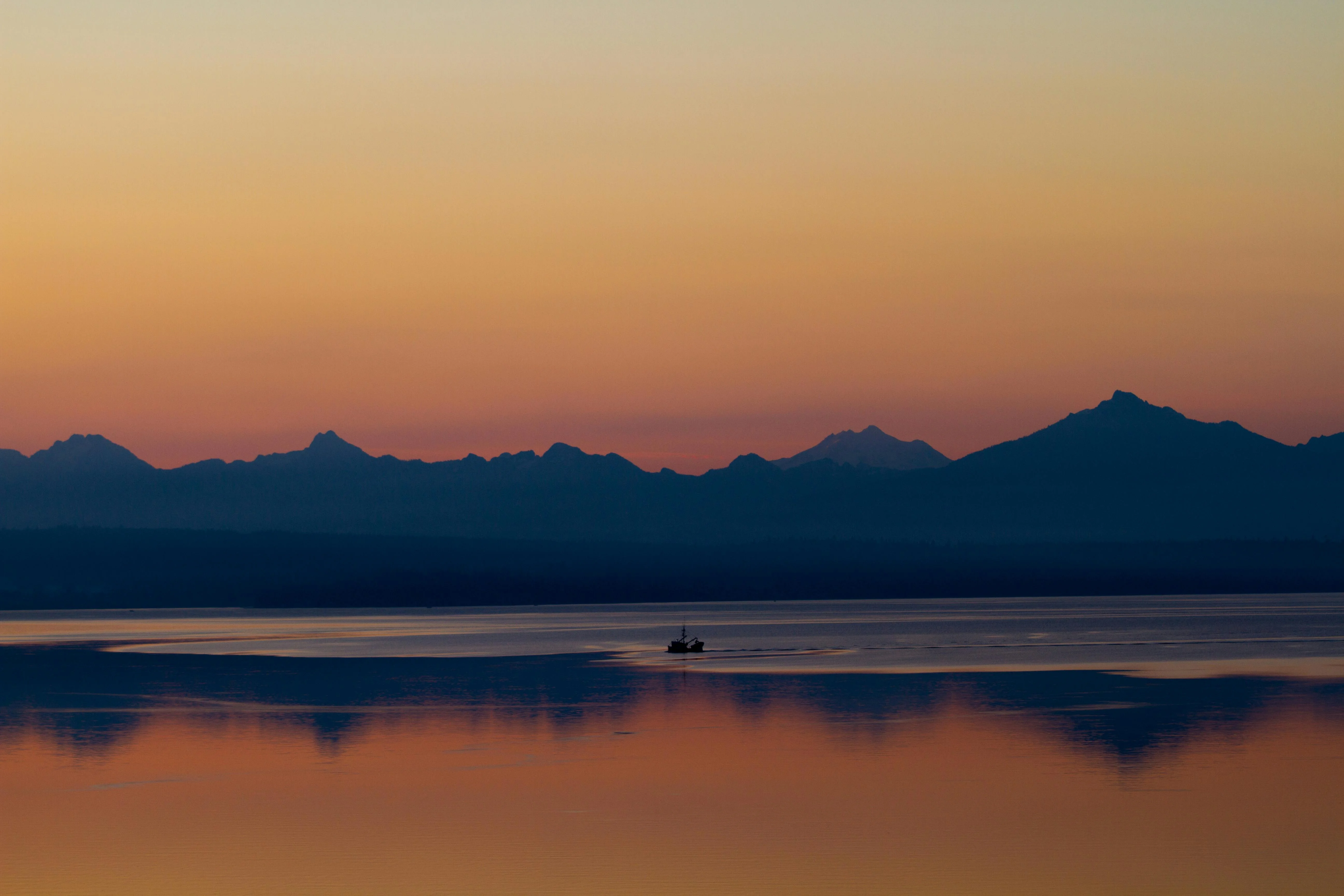 Black luxury chauffeur sedan at the Edmonds ferry terminal at golden hour