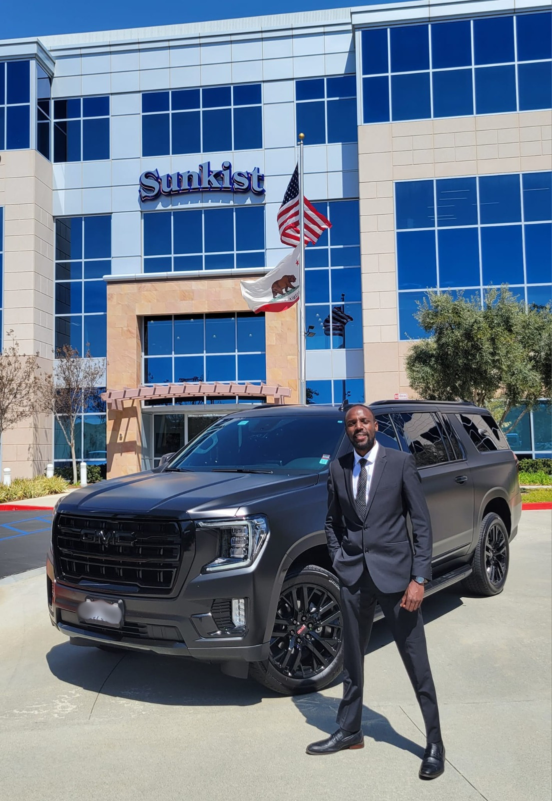 Emerald City Limos founder Ken Dabb beside a black Cadillac Escalade in downtown Seattle