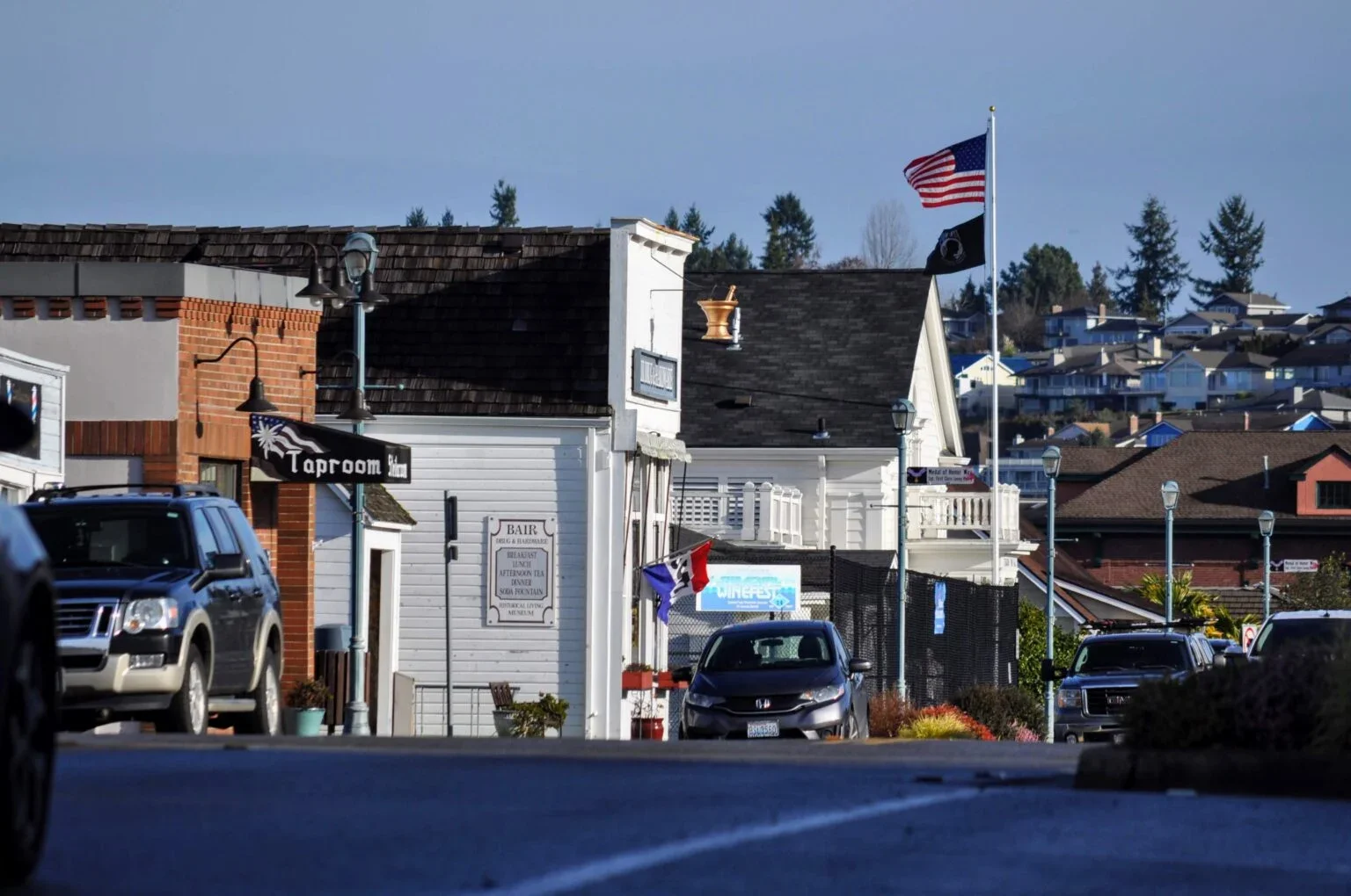 Luxury black chauffeur sedan overlooking Steilacoom waterfront at sunset